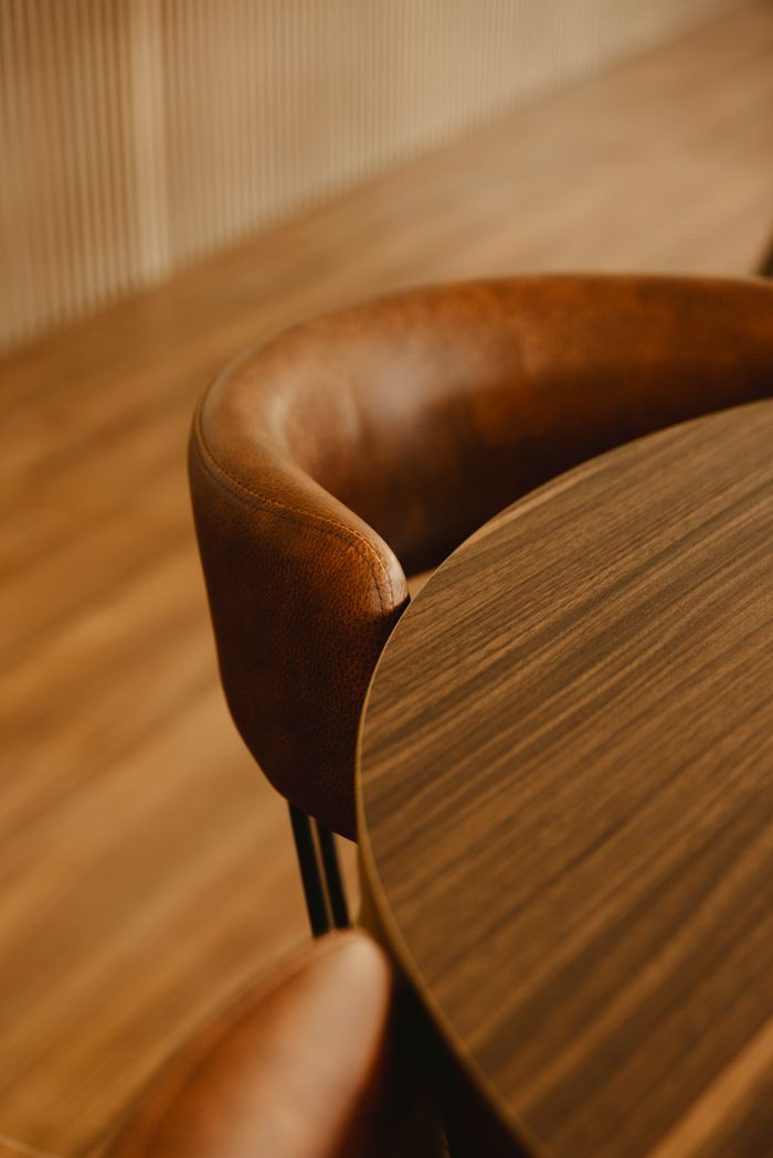 Crafting Captivating Headlines: Your awesome post title goes here A stylish brown leather chair next to a smooth wooden table in a warm indoor setting.