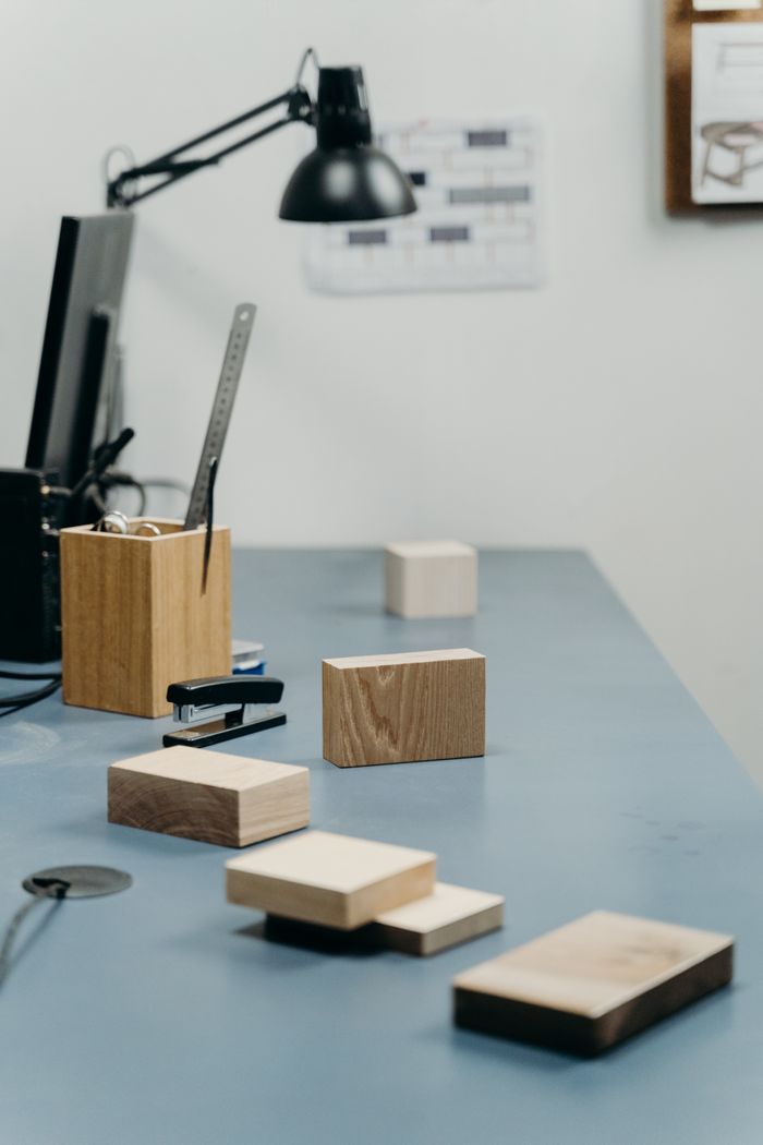 Mastering the First Impression: Your intriguing post title goes here Contemporary office desk featuring wooden samples, a black desk lamp, and office supplies.